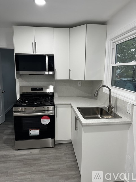 A kitchen with white cabinets and a black stove top oven.