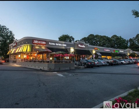 A Zod's Kitchen restaurant is lit up at dusk with cars parked in the lot.