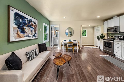 A living room with a couch, a coffee table, and a painting on the wall.