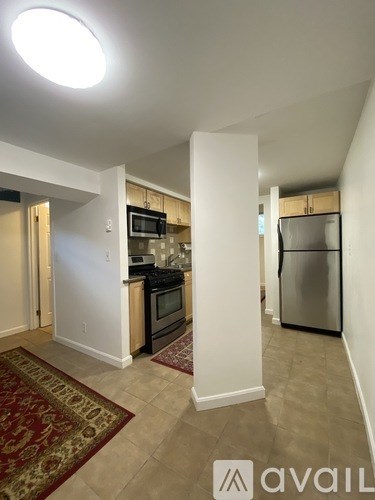 A kitchen with a refrigerator, microwave, and oven.