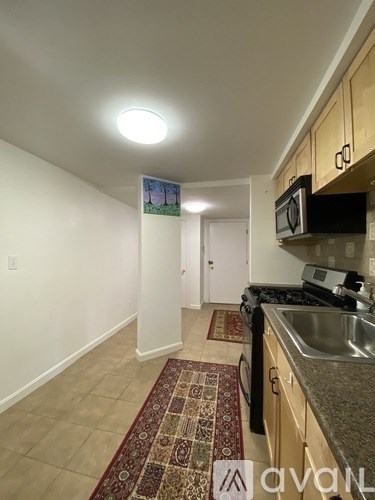 A kitchen with a sink and a fridge.