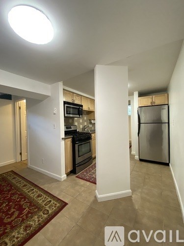 A kitchen with a refrigerator, microwave, and oven.