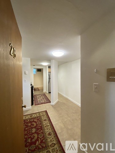 A hallway with a rug on the floor and a door with the number 28 on it.