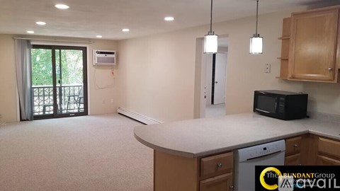 A kitchen with a black microwave oven on the counter.