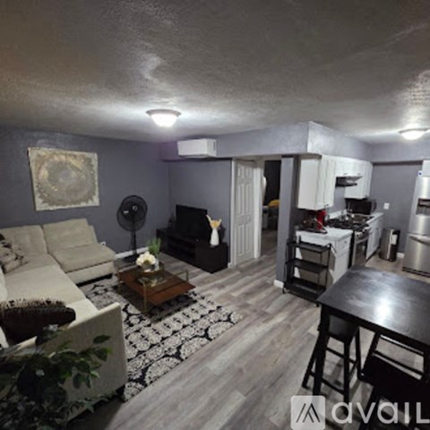 A living room with a couch, coffee table, and a painting on the wall.