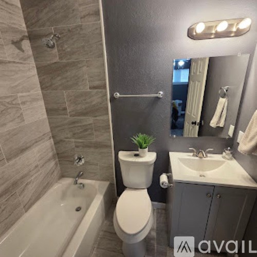 A bathroom with a toilet, sink, and tub.
