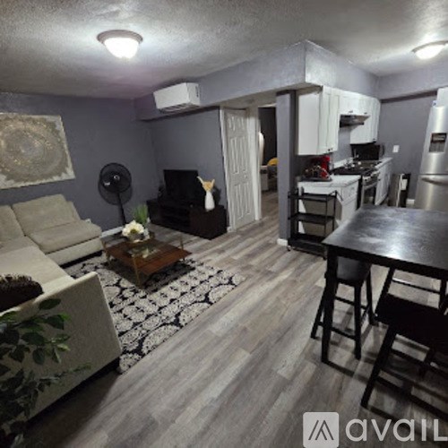 A living room with a couch, coffee table, and a dining area.
