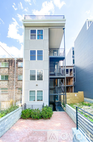 A modern two-story building with a balcony and staircase.