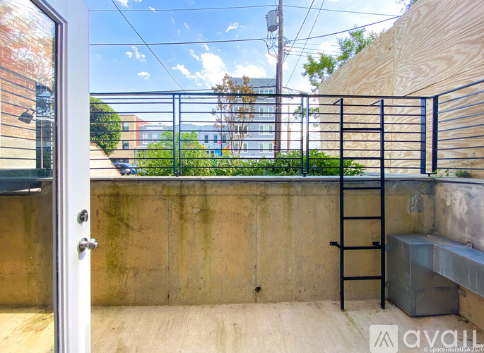 A balcony with a metal railing and a concrete wall.