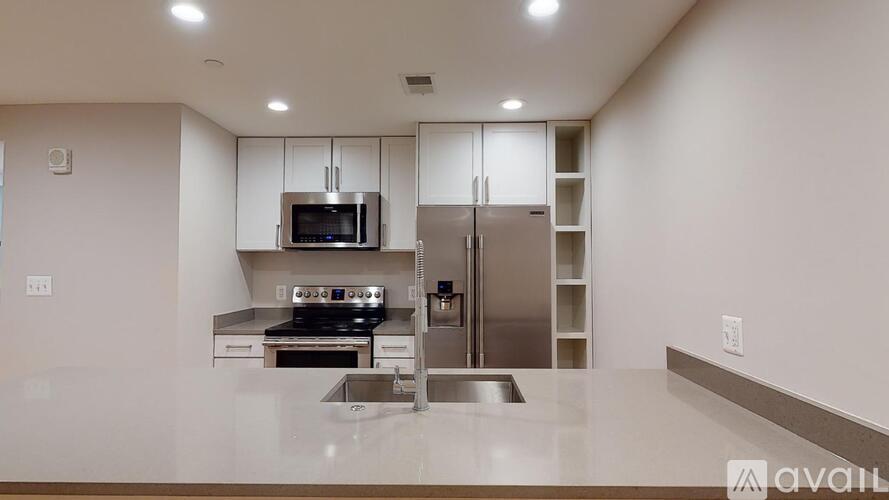 A modern kitchen with stainless steel appliances and white cabinets.