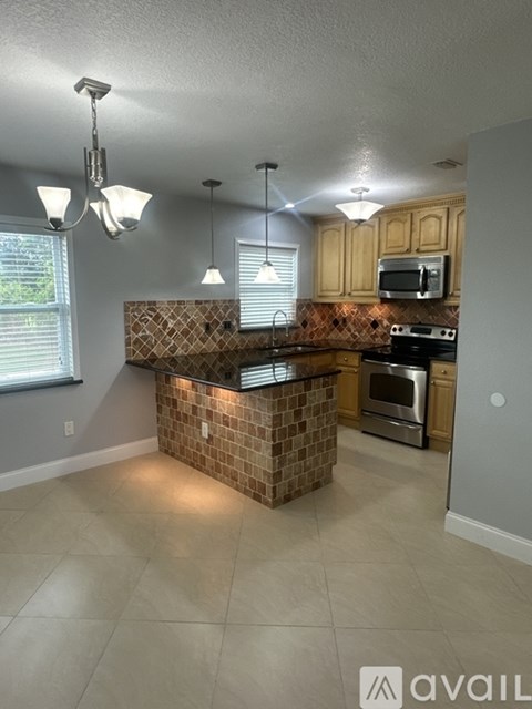 A kitchen with a brick backsplash and a microwave above the oven.