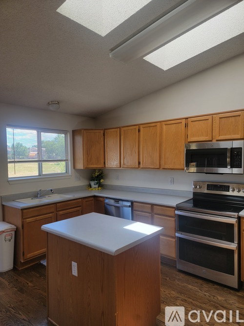 A kitchen with wooden cabinets and a stainless steel dishwasher.