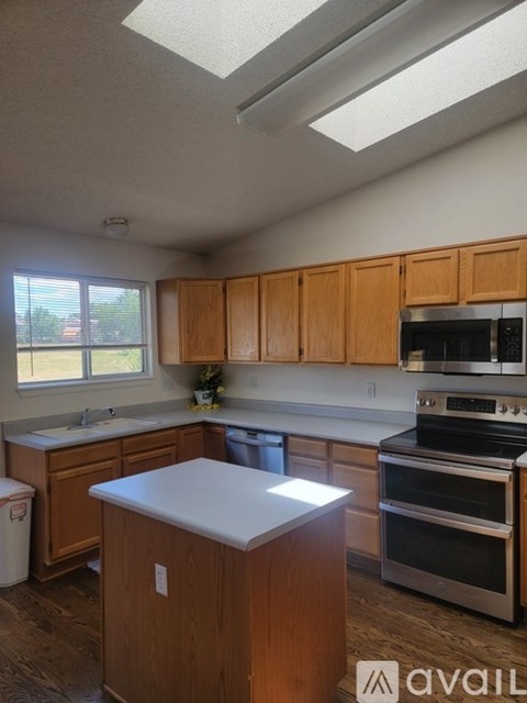 A kitchen with wooden cabinets and a stainless steel dishwasher.
