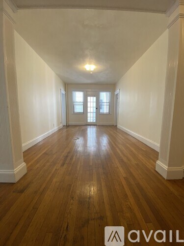 A long hallway with wooden floors and white walls.