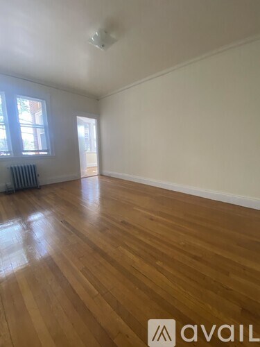 A room with wooden flooring and a window.