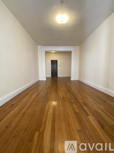 A hallway with wooden floors and a light on the ceiling.