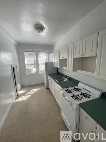 A kitchen with white cabinets and a white stove top oven.
