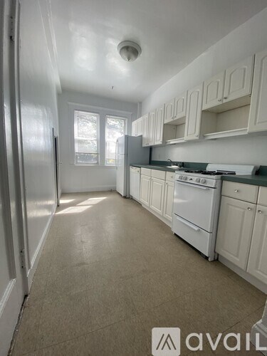 A kitchen with white appliances and cabinets.
