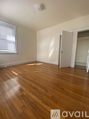 A room with wooden flooring and a window.