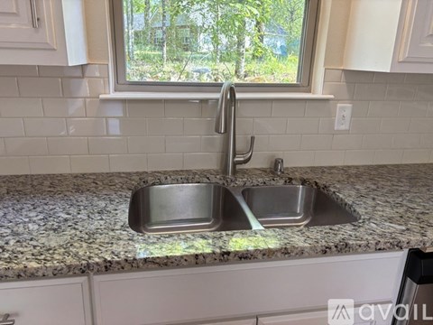 A kitchen sink with a window above it.