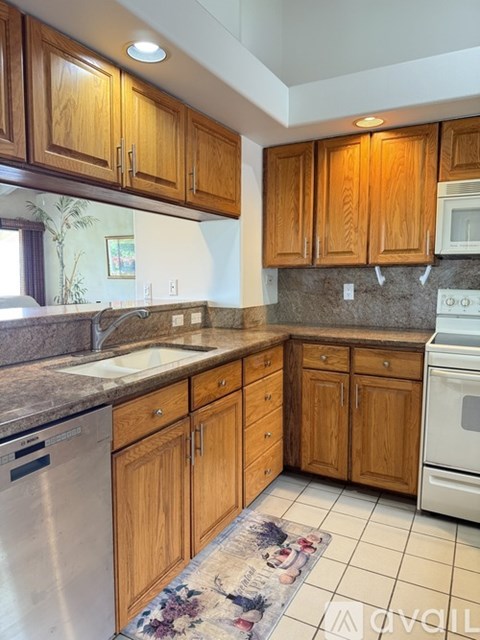 A kitchen with wooden cabinets and a stainless steel dishwasher.