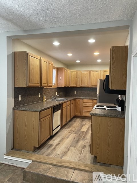 A kitchen with wooden cabinets and a granite countertop.