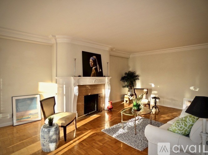A living room with a fireplace and a painting on the wall.