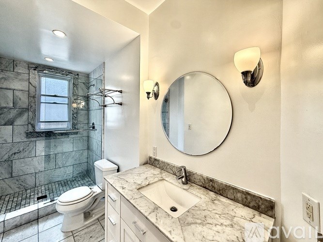 A view of a cityscape from a high vantage point with buildings of various sizes and a tree on the left.