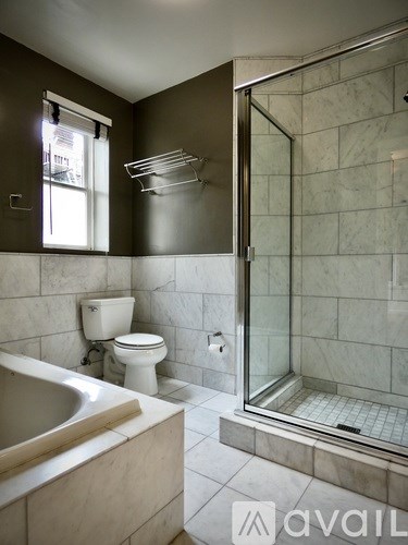 A bathroom with a toilet, sink, and shower.