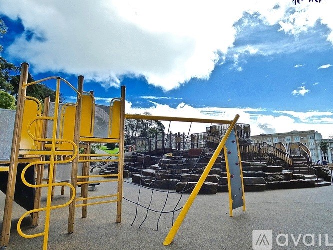 A playground with a yellow slide and black swings.