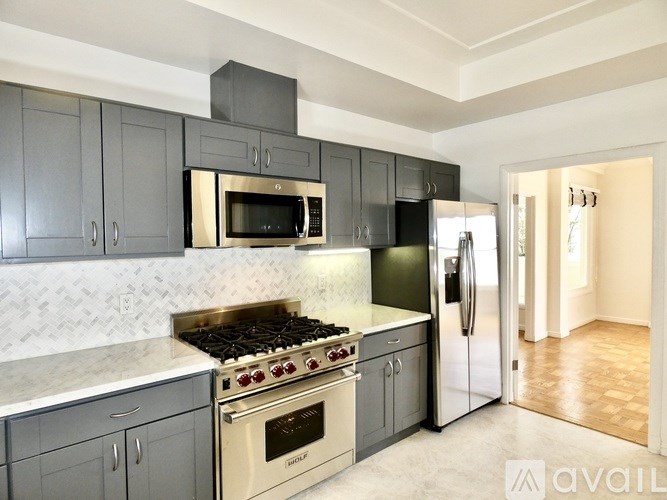 A kitchen with a stove top oven and a refrigerator.