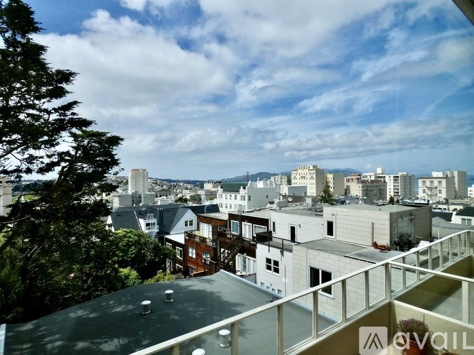A view of a cityscape from a high vantage point with buildings of various sizes and a tree on the left.