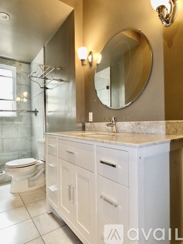 A bathroom with a toilet, sink, and mirror.