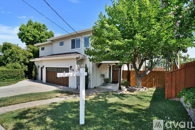 A house with a white fence and a brown garage door.