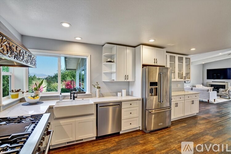 A modern kitchen with stainless steel appliances and wooden floors.