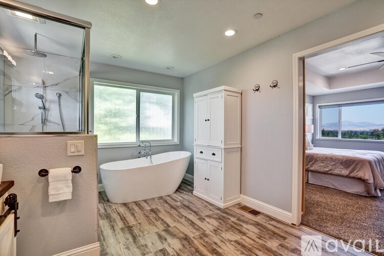 A bathroom with a tub, sink, and shower.