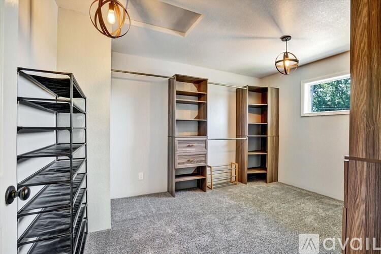 A room with a white wall and a black shelving unit.