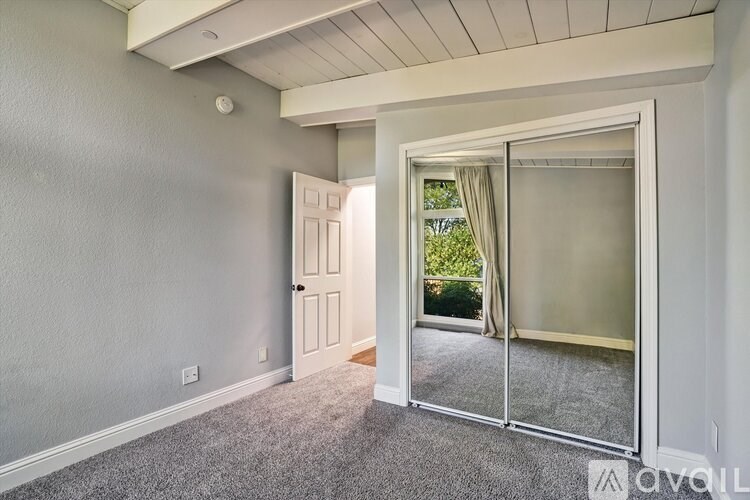 A room with a sliding glass door leading to a balcony.