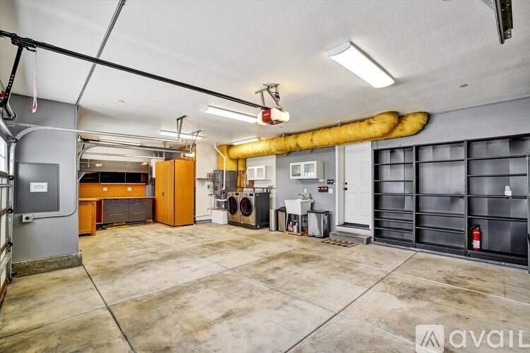 A large, empty industrial space with a yellow pipe running along the ceiling.