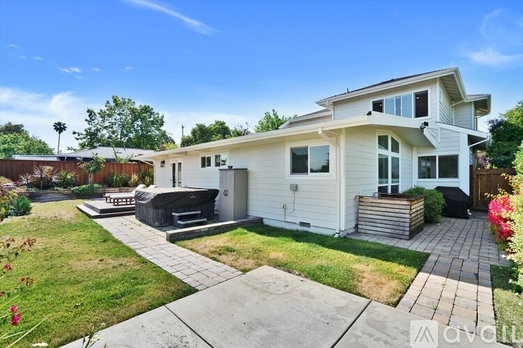A house with a white exterior and a small garden in front.
