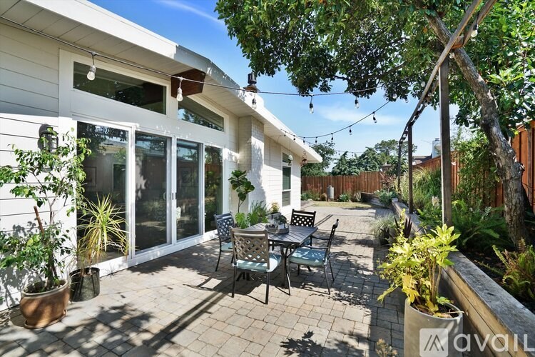 A patio area with a table and chairs outside a house.