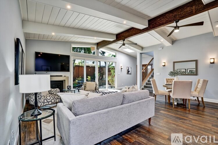A living room with a grey couch and a television on the wall.