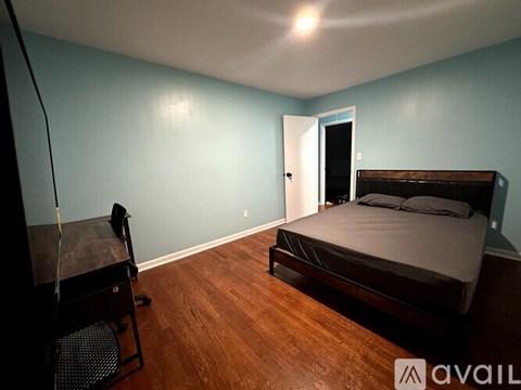 A bedroom with a bed, chair, and a table.