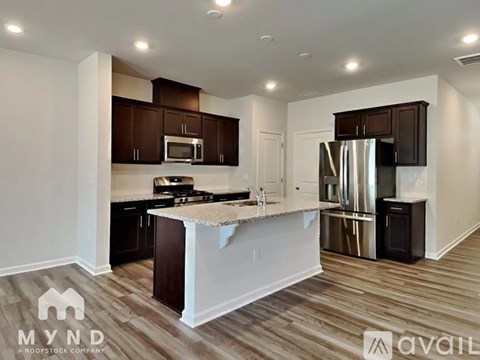 A kitchen with wooden cabinets and a white island.