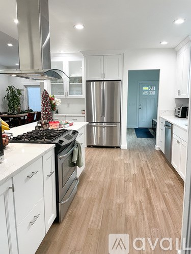 A kitchen with white cabinets and a blue door.