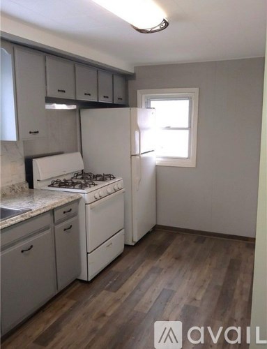 A kitchen with a stove, sink, and cabinets.
