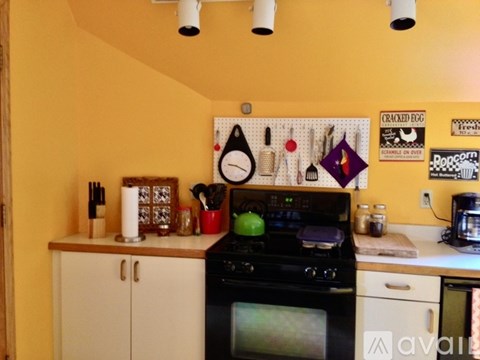 A kitchen with yellow walls and a black stove top oven.