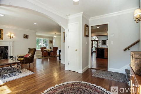 A living room with a fireplace and a rug on the floor.