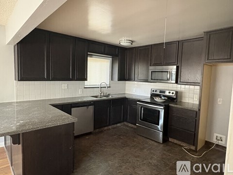 A kitchen with black cabinets and stainless steel appliances.