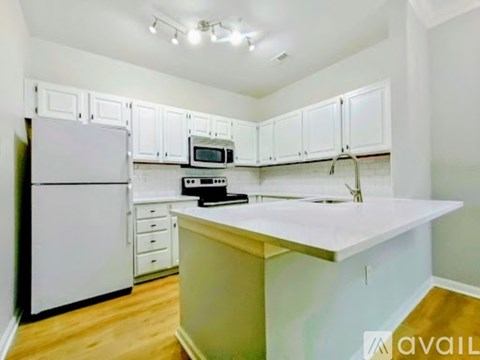 A kitchen with white cabinets and a white refrigerator.